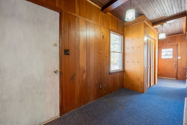 interior space with beam ceiling, wood ceiling, carpet flooring, and wood walls