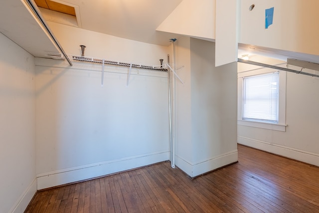 walk in closet with dark hardwood / wood-style flooring