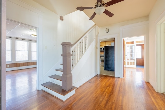 stairway with ceiling fan and hardwood / wood-style floors