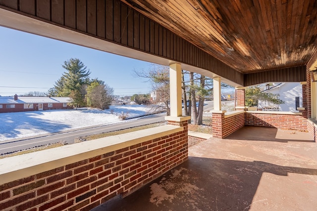 snow covered patio with a porch