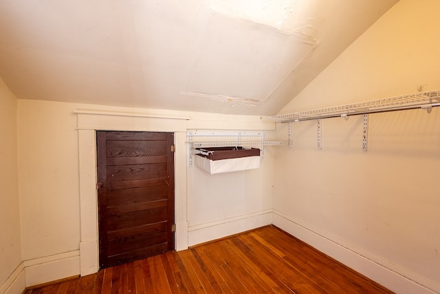 walk in closet featuring wood-type flooring and vaulted ceiling