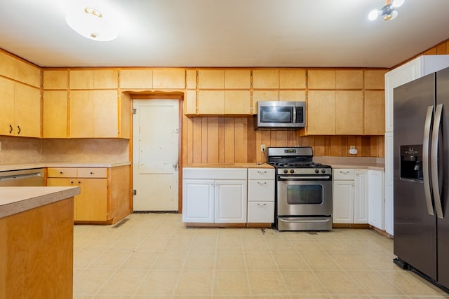 kitchen with appliances with stainless steel finishes and wooden walls