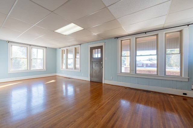 spare room with hardwood / wood-style floors and a drop ceiling