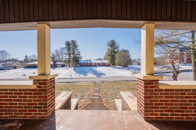 snow covered patio featuring covered porch