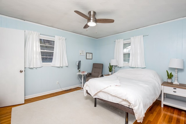 bedroom featuring ceiling fan, ornamental molding, and dark hardwood / wood-style floors