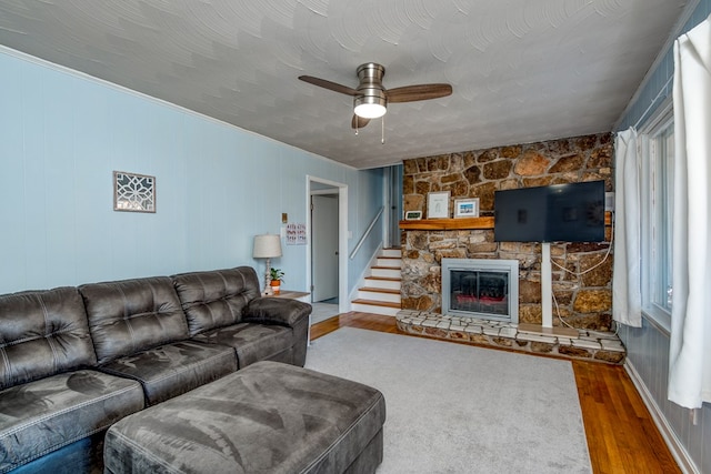 living room featuring hardwood / wood-style flooring, ceiling fan, a fireplace, a healthy amount of sunlight, and a textured ceiling