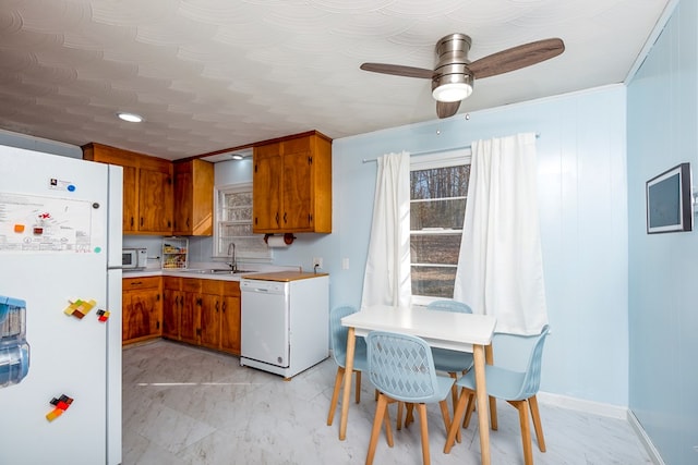 kitchen with sink, white appliances, and ceiling fan