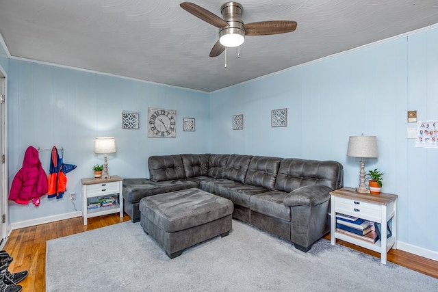 living room featuring hardwood / wood-style flooring, ceiling fan, and crown molding