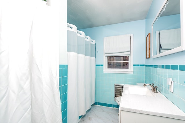 bathroom featuring vanity, toilet, curtained shower, and tile walls