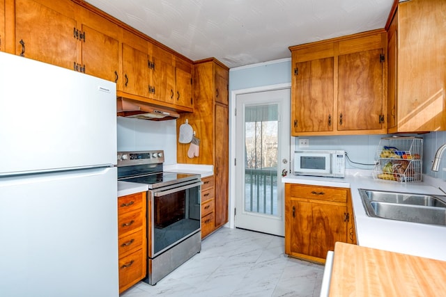 kitchen with sink, white appliances, and range hood