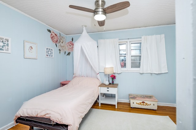 bedroom featuring hardwood / wood-style flooring, ceiling fan, and ornamental molding