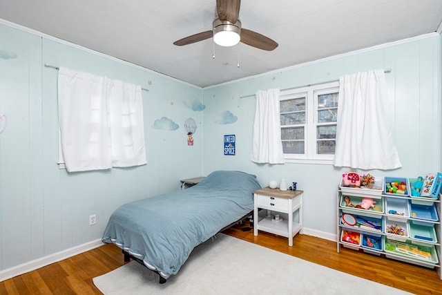 bedroom with wood-type flooring, crown molding, and ceiling fan