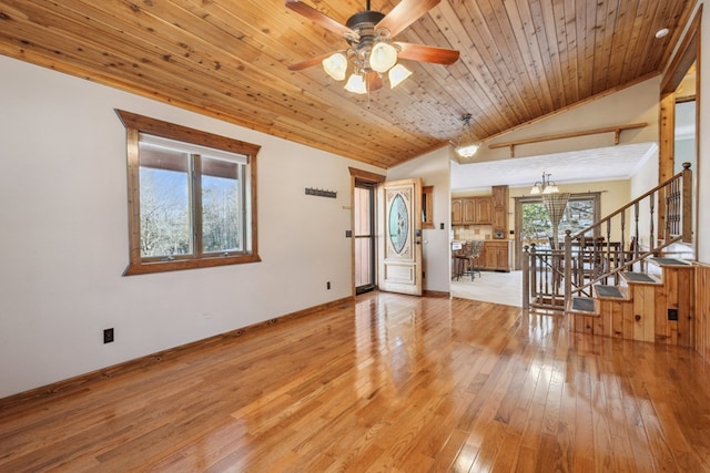 unfurnished living room featuring lofted ceiling, stairway, light wood-style floors, wooden ceiling, and ceiling fan with notable chandelier