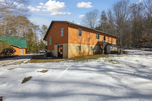 view of snowy exterior with cooling unit