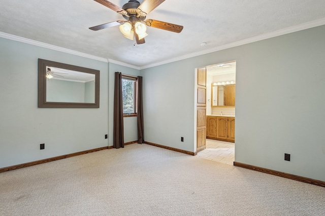 empty room with light colored carpet, crown molding, a textured ceiling, and baseboards