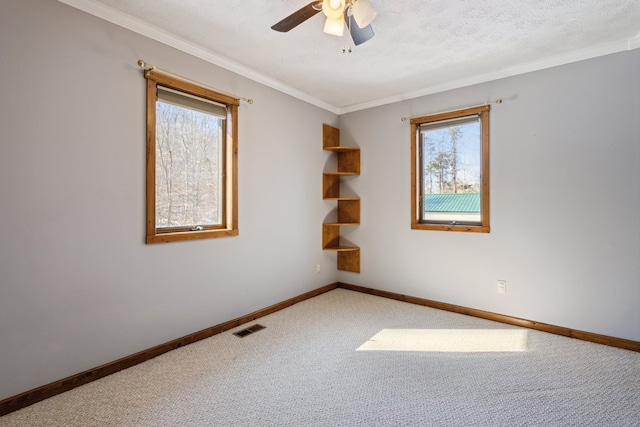 empty room with carpet, visible vents, crown molding, and a textured ceiling