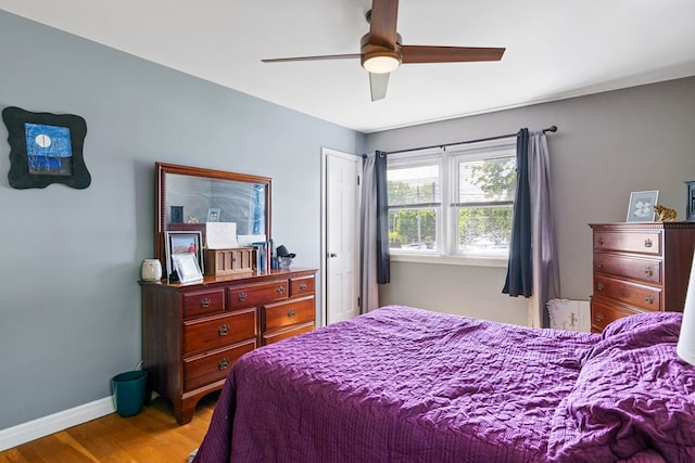 bedroom with wood finished floors, a ceiling fan, and baseboards