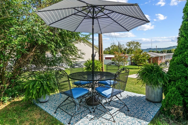 view of patio / terrace with outdoor dining space and a mountain view