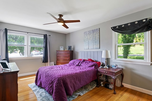 bedroom with ceiling fan, baseboards, and wood finished floors