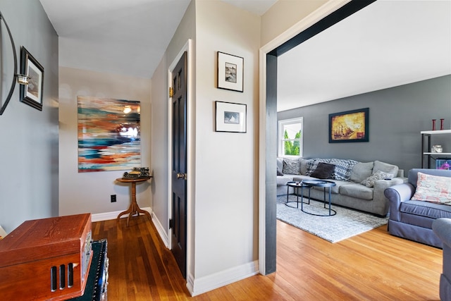 hallway featuring wood finished floors and baseboards