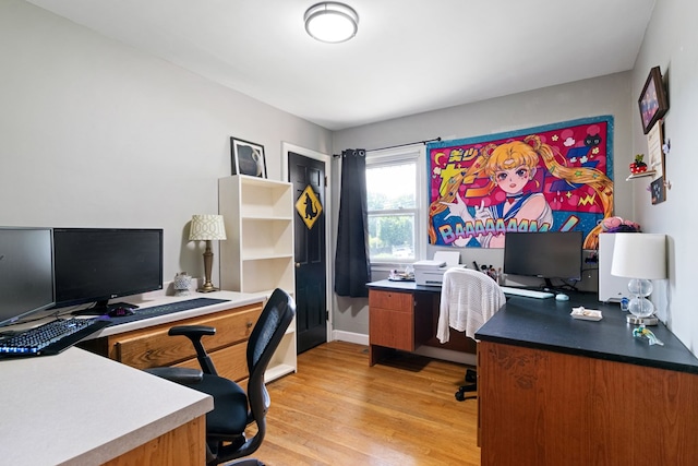 office area with baseboards and light wood finished floors