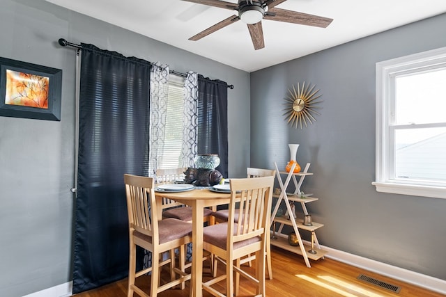 dining area with ceiling fan, wood finished floors, visible vents, and baseboards