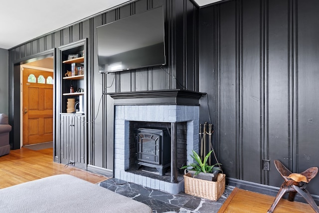 living area with a wood stove and wood finished floors