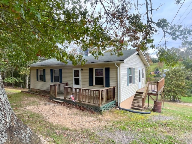 view of front of house featuring a wooden deck and a front lawn