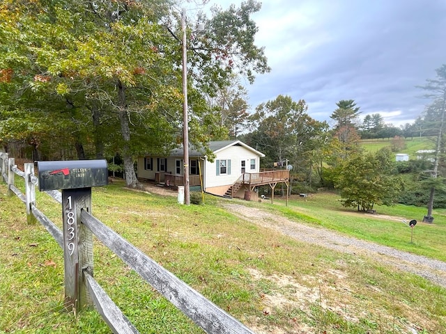 view of front of property with a wooden deck and a front yard