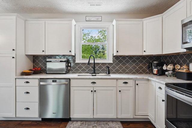 156 Ridgecrest St, Bluefield, VA 24605 - kitchen featuring appliances with stainless steel finishes, a sink, white cabinets, light countertops, and a textured ceiling