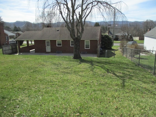 view of yard featuring a patio area, fence, and a mountain view