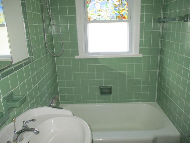 bathroom with tub / shower combination and a sink