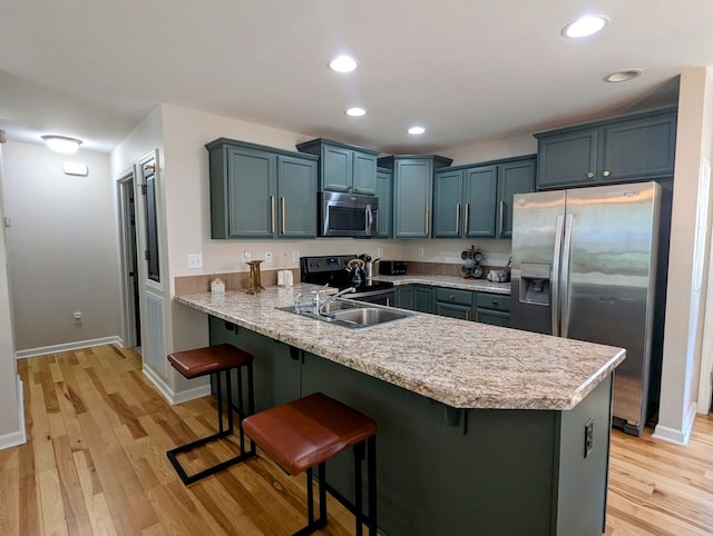 1251 Epperly Mill Rd, Floyd, VA 24091 - kitchen with appliances with stainless steel finishes, a peninsula, a breakfast bar, light wood-type flooring, and recessed lighting