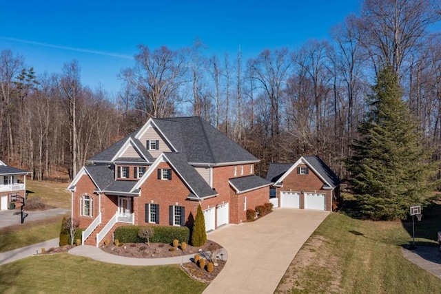 traditional-style house with brick siding, an outdoor structure, concrete driveway, and a front yard