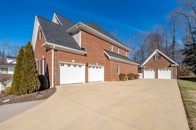 view of side of home featuring driveway and brick siding