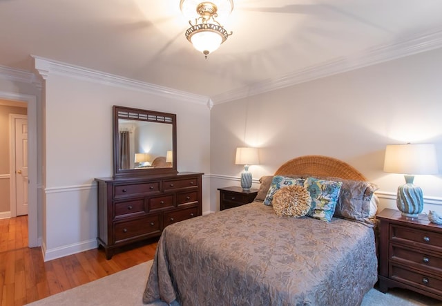 bedroom with baseboards, light wood-type flooring, and crown molding