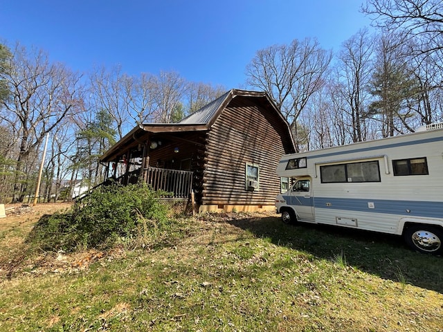 view of home's exterior featuring a gambrel roof, metal roof, covered porch, and log exterior