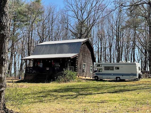 view of front of home with a front yard, metal roof, crawl space, a gambrel roof, and log siding
