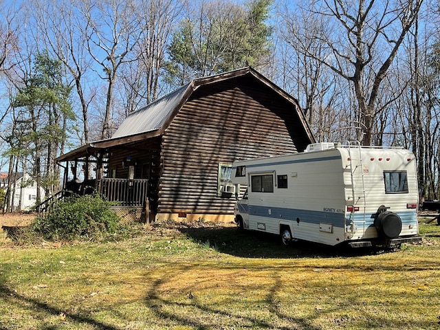view of property exterior with a gambrel roof, metal roof, and a lawn