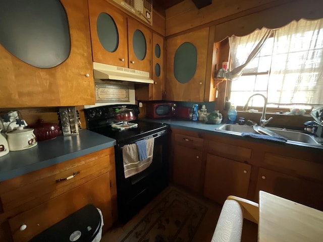 kitchen with black electric range, under cabinet range hood, a sink, and brown cabinetry