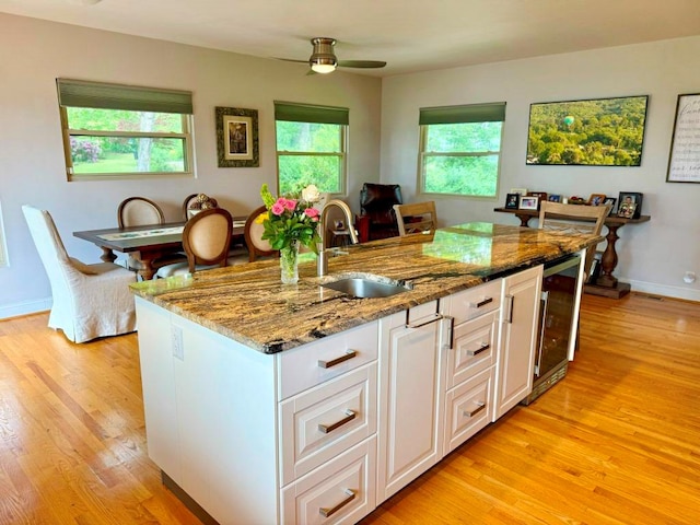 675 Pine Ridge Rd, Wytheville, VA 24382 - kitchen featuring beverage cooler, light wood-style flooring, light stone counters, and ceiling fan