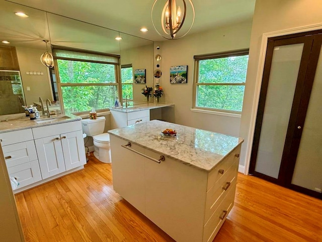 675 Pine Ridge Rd, Wytheville, VA 24382 - kitchen with light wood finished floors, a chandelier, white cabinets, light stone countertops, and hanging light fixtures