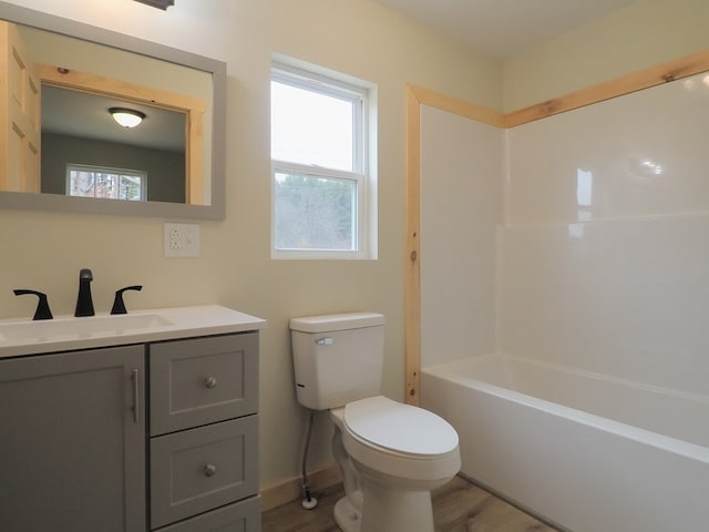 full bathroom with shower / bath combination, vanity, hardwood / wood-style floors, and toilet