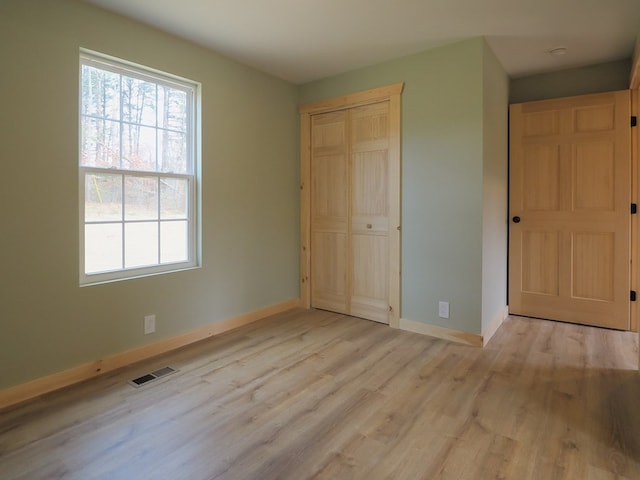 unfurnished bedroom with light hardwood / wood-style floors and a closet