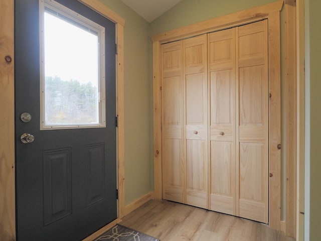 entryway with vaulted ceiling and light hardwood / wood-style floors