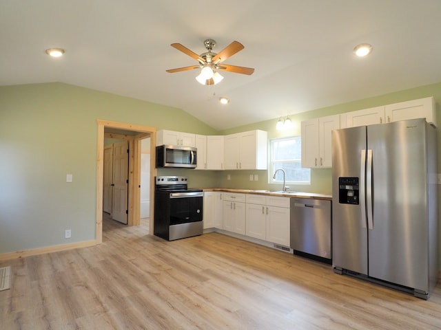 kitchen featuring white cabinetry, sink, vaulted ceiling, and appliances with stainless steel finishes