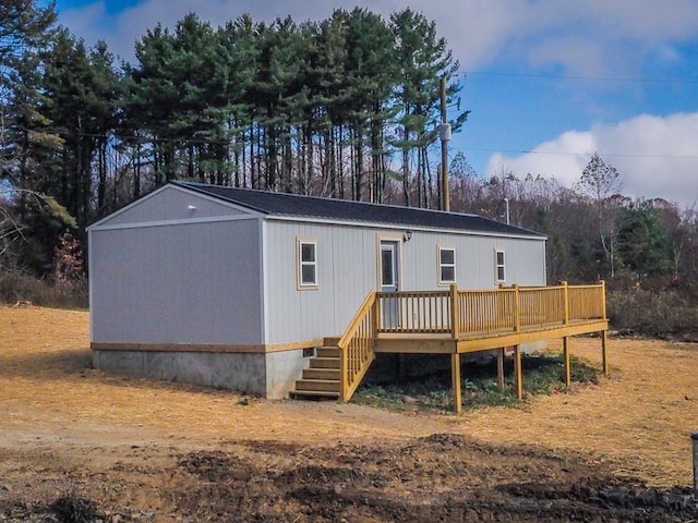 rear view of property featuring a wooden deck