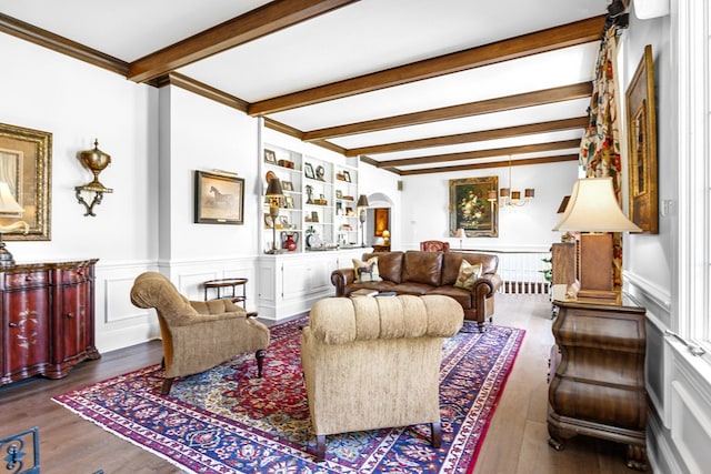living room featuring wainscoting, beam ceiling, wood finished floors, and arched walkways