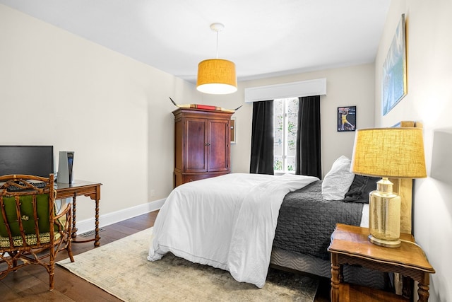 bedroom featuring baseboards and wood finished floors