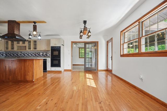 271 Burgan Rd, Pennington Gap, VA 24277 - kitchen featuring wall chimney exhaust hood, a chandelier, backsplash, glass insert cabinets, and light wood-type flooring